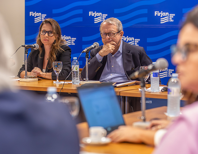 Secretária Fernanda Curdi e Mauro Viegas, da federação, observam a apresentação sobre as ações do governo do estado do Rio